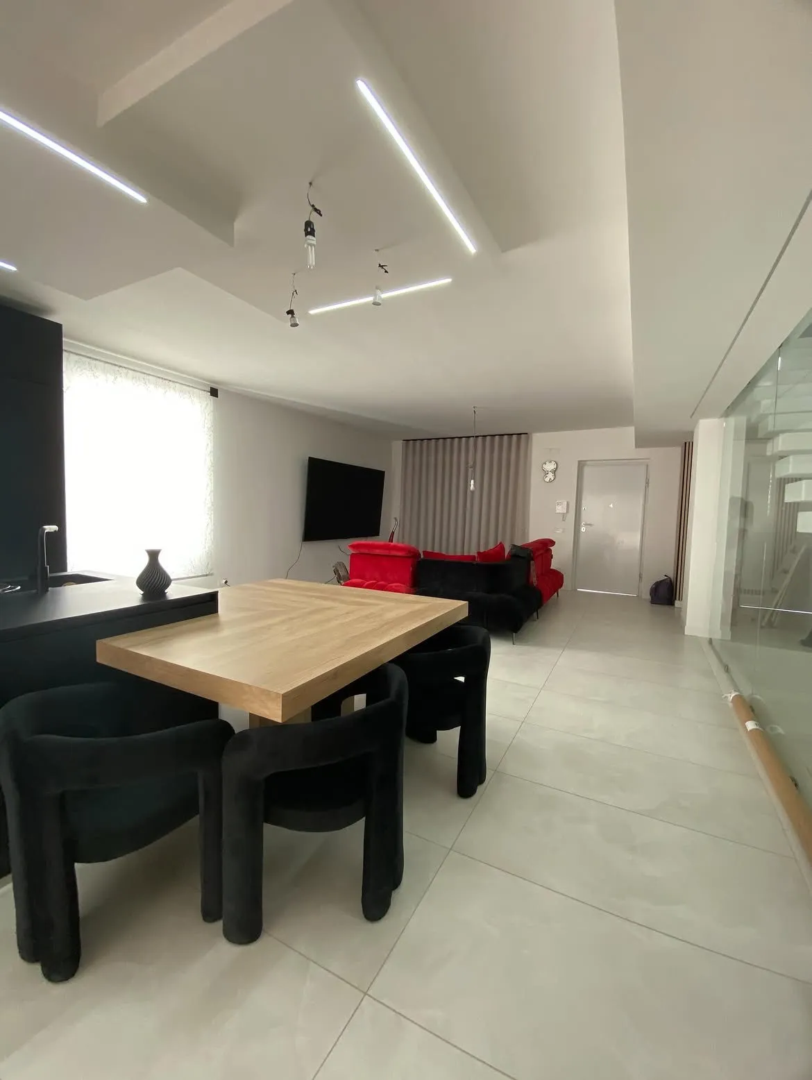 Open space con tavolo in legno e tende velate